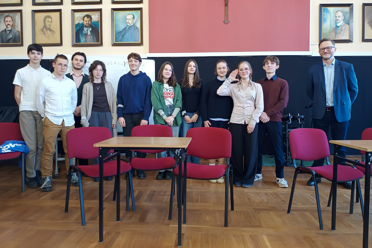 zdjęcie: jedenaście osób stoi na podium w sali