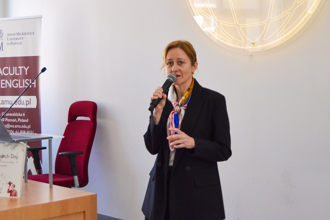 photograph: person with a microphone in hand addresses the audience (who are out of frame)