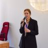 photograph: person with a microphone in hand addresses the audience (who are out of frame)