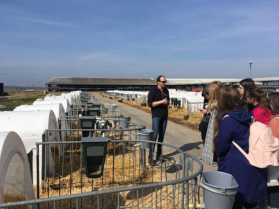 photograph: a group of people visiting a farm, the guide addresses the visitors