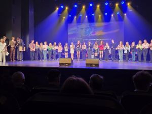 zdjęcie: grupa kilkudziesięciu osób stoi na scenie