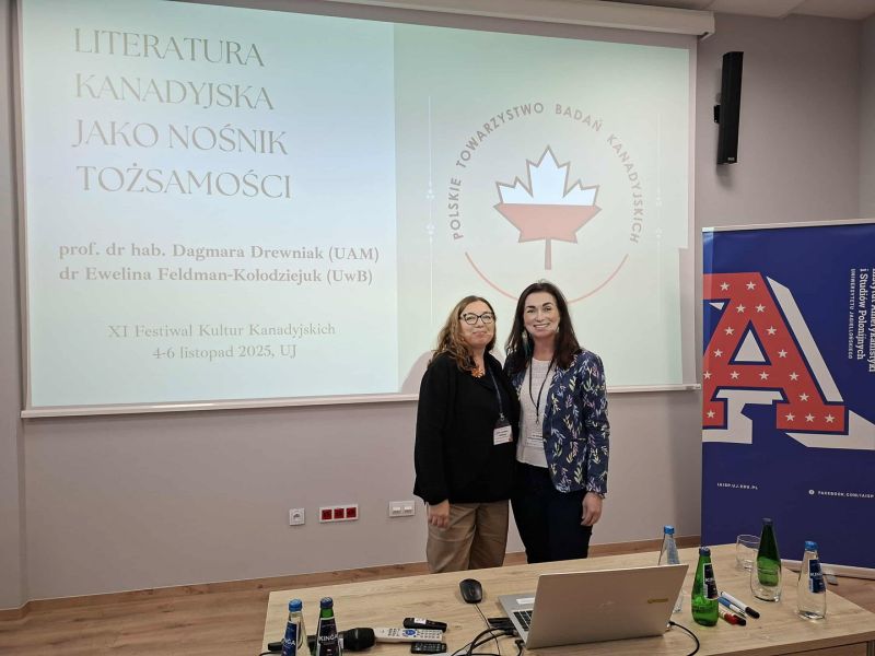 zdjęcie: dwie osoby stoją przed ekranem w sali seminaryjnej; na ekranie: sjald tytułowy prezentacji