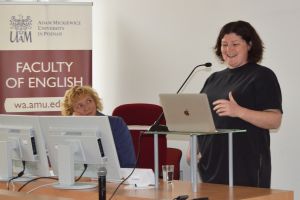 photograph: a person addresses the audience from behind the pulpit; another person looks at the speaker