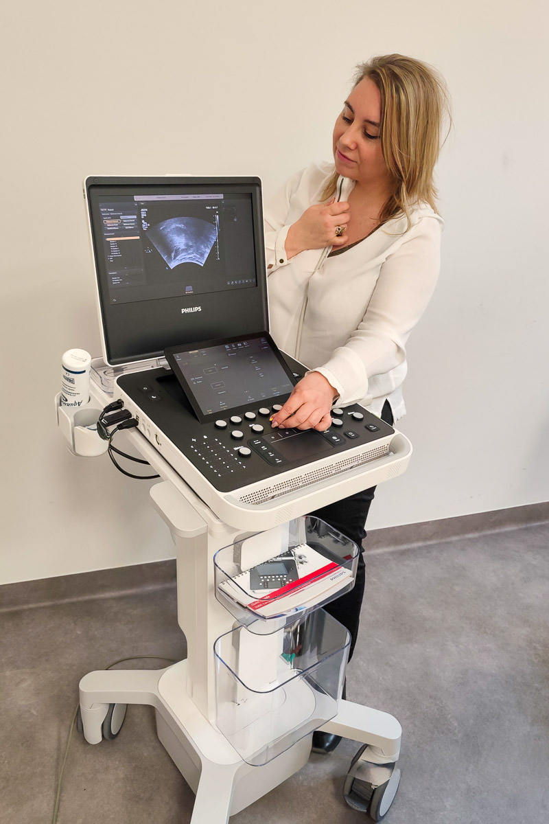 photograph: a person stands next to an ultrasound device in a laboratory