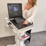 photograph: a person stands next to an ultrasound device in a laboratory