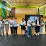 zdjęcie: sala gimnastyczna; grupa trzynastu osób pozuje, stojąc; wszystkie oprócz jednej trzymają w rękach dyplomy