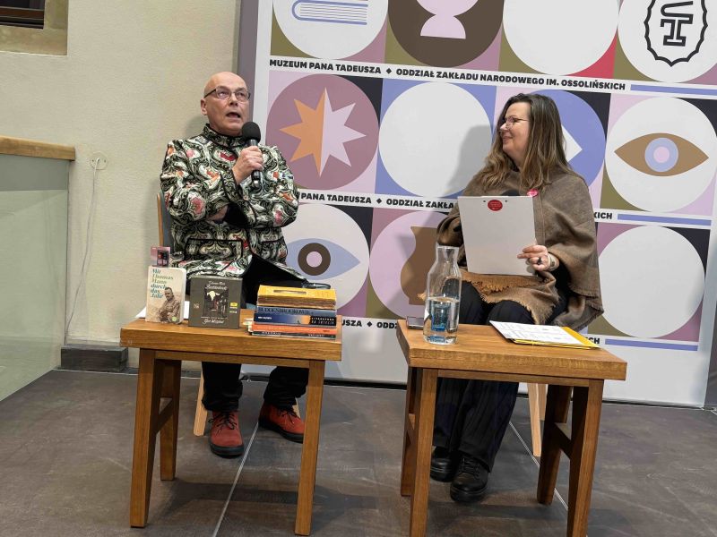 Zdjęcie przedstawiające prof. Kocha trzymającego mikrofon i rozmawiającego z Małgorzatą Słabicką-Turpeinen
