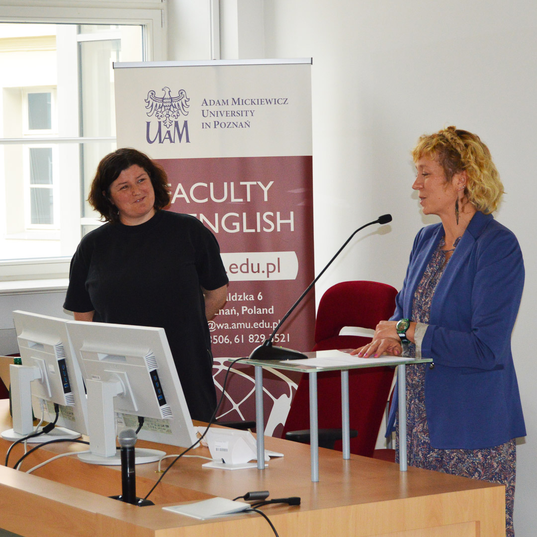 photograph: a person addresses the audience from behind the pulpit; another person looks at the speaker