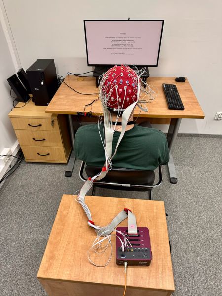 photopgraph: person sitting in front of a desk during an electroencephalograph experiment