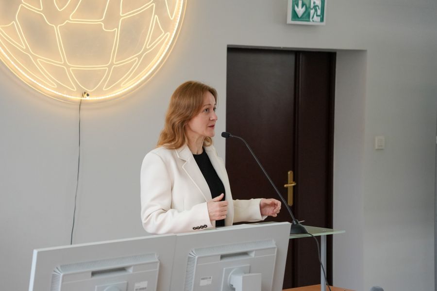 zdjęcie: osoba stoi w sali wykładowej